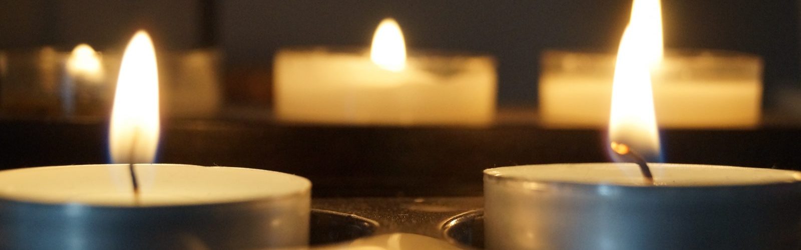 Picture of tea light candles in holders suggesting prayer candles.